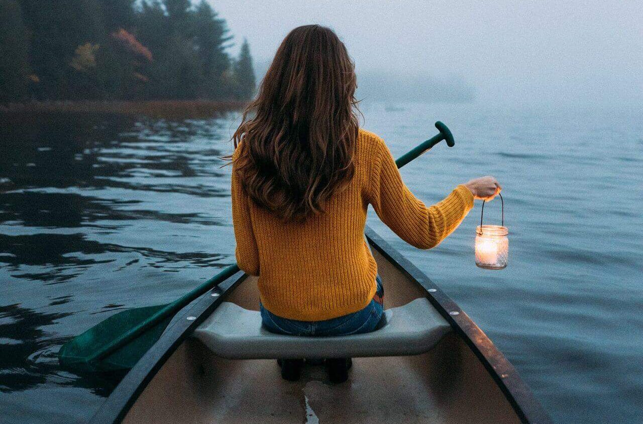 woman solo travelling in the middle of the lake in a boat