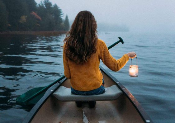 woman solo travelling in the middle of the lake in a boat