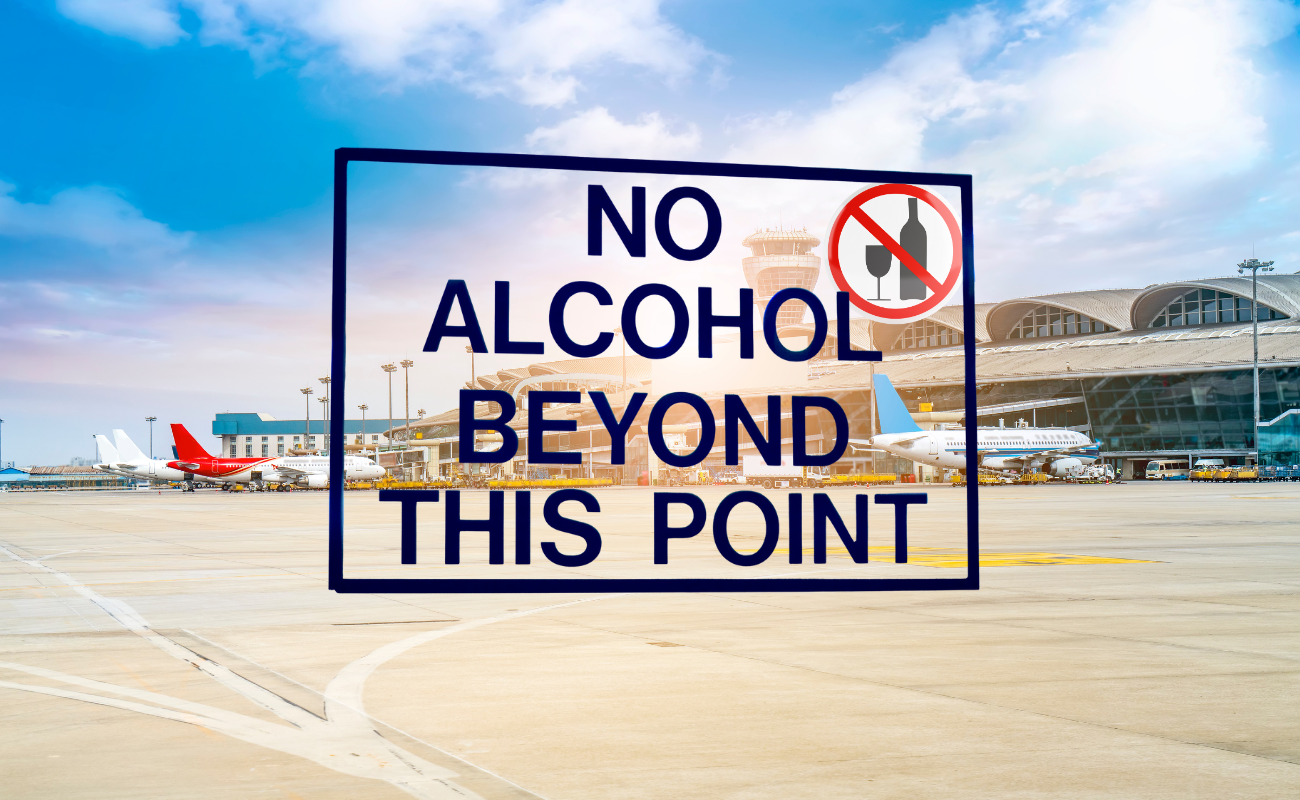 Airport security sign stating no alcohol allowed beyond this point near terminal gates.