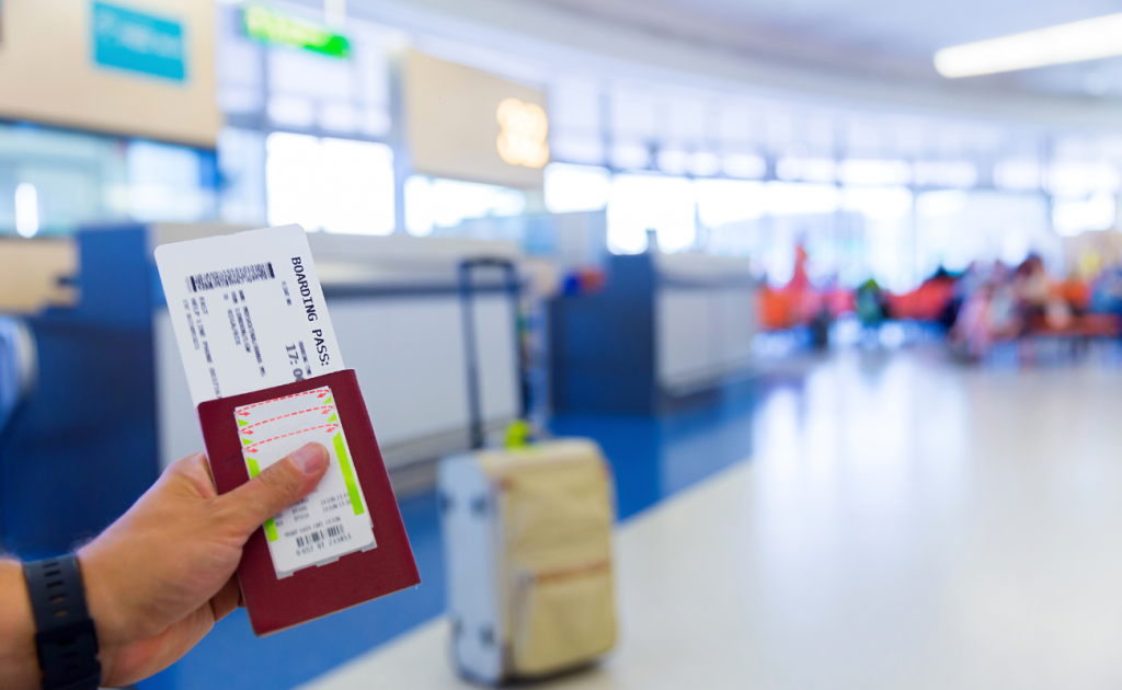 Boarding pass won't scan and passport held at an airport gate with seating area in background