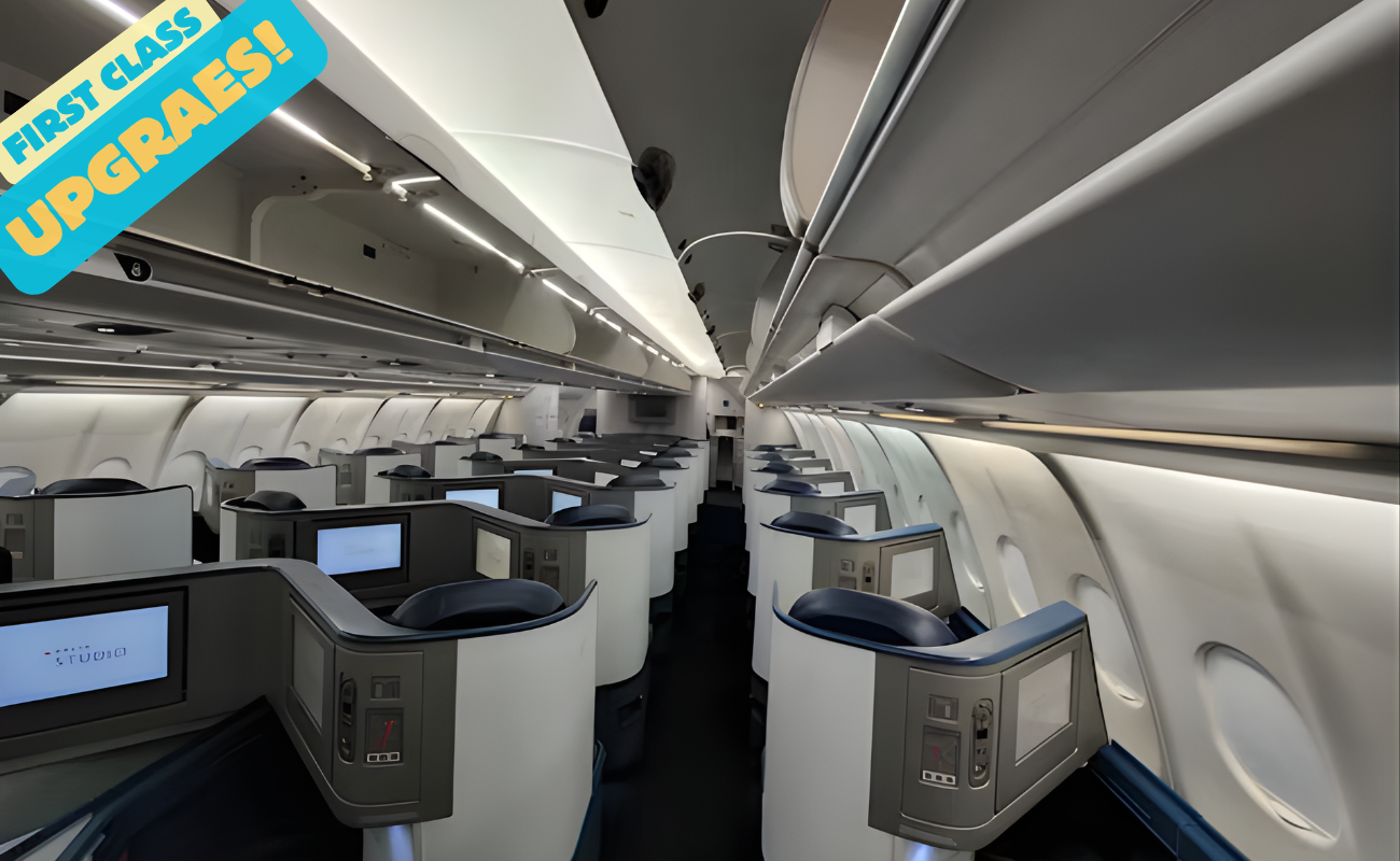 Empty first-class airplane cabin with private lie-flat pods and screens. Bold overlay: "FIRST CLASS UPGRADES!"