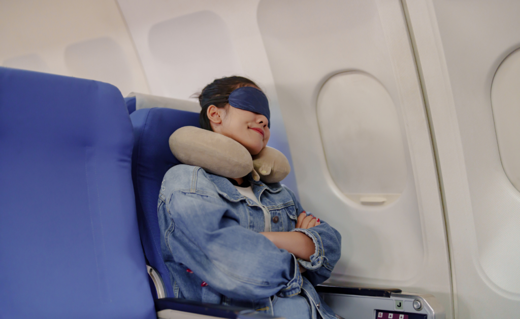 Girl wearing an eye mask and sleeping comfortably on red-eye flights sleep on overnight flights.