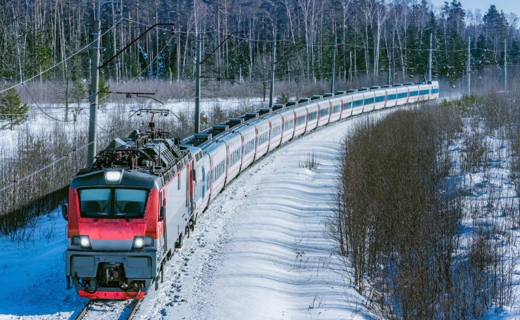 Passenger train traveling through a snowy European landscape