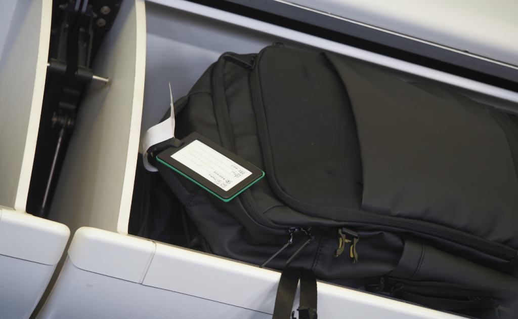 Carry-on backpack secured inside an airplane overhead bin.