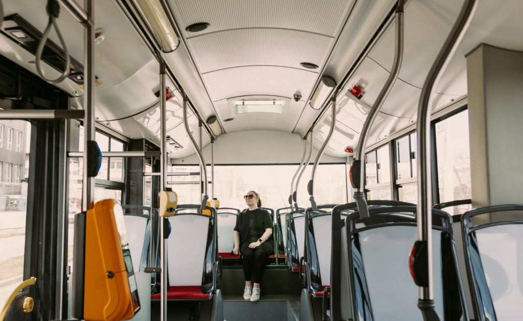 Solo traveler sitting alone on a city bus while traveling through Europe