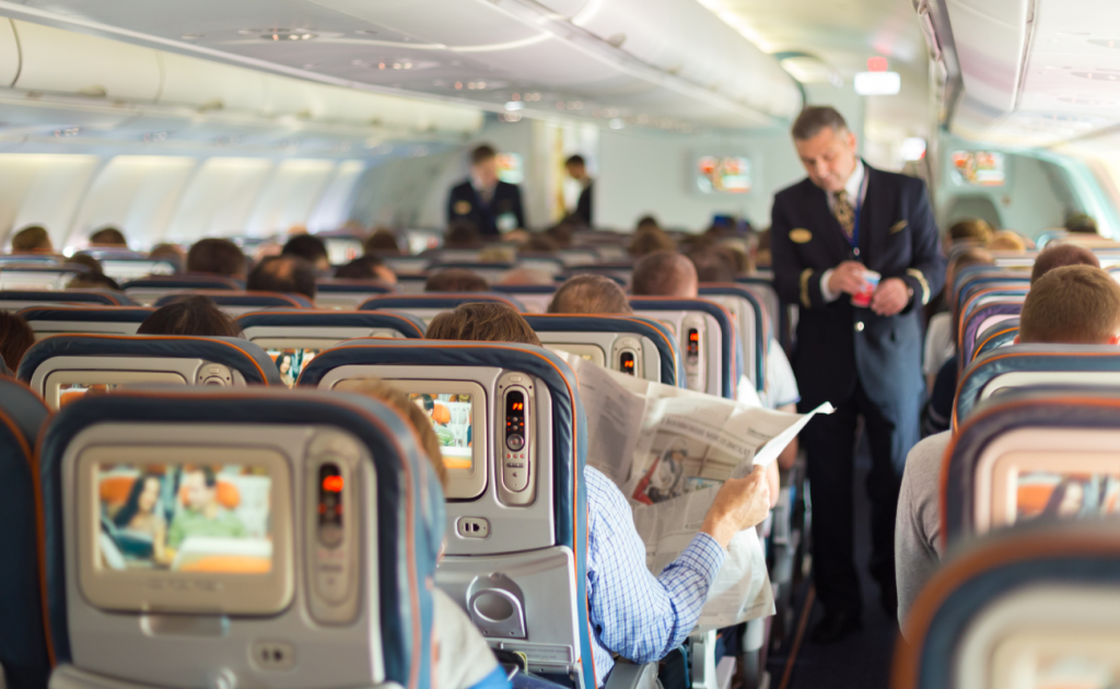 Flight attendant assisting passengers in the cabin after seat changes under 2026 airline policies.