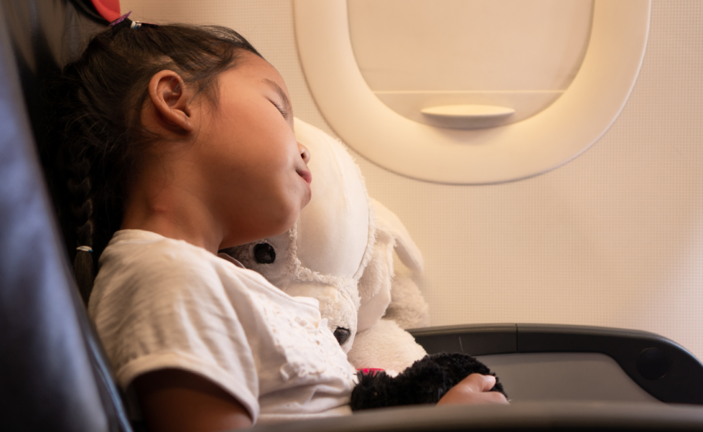 Child sleeping with a teddy bear during red-eye flights sleep on overnight flights.