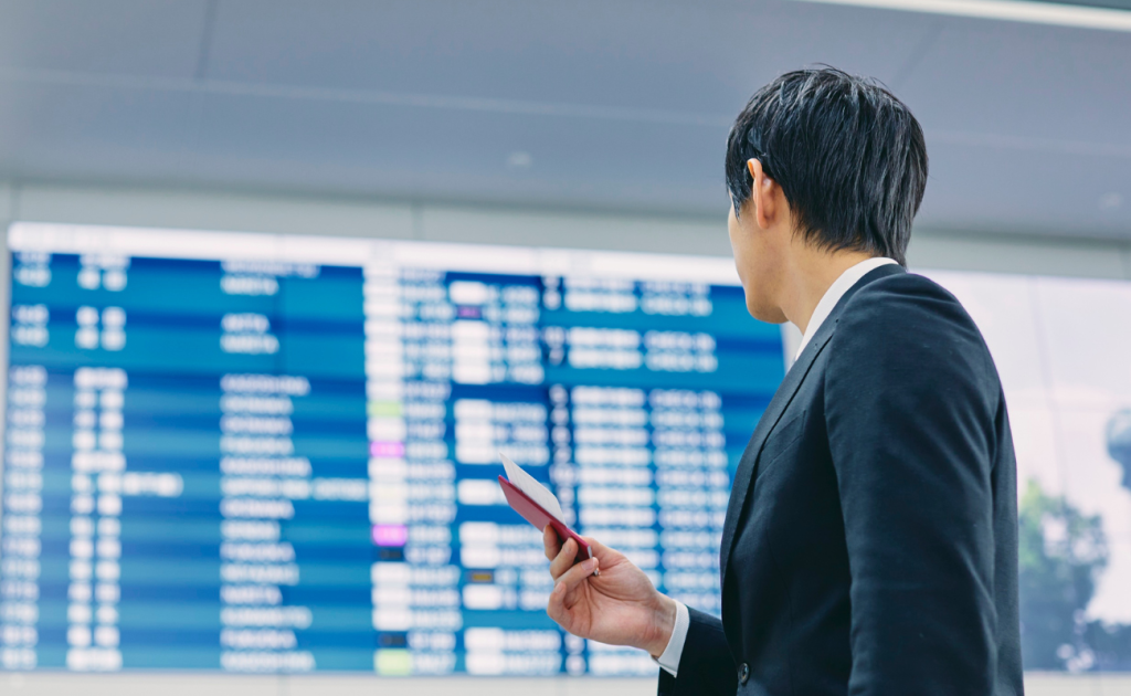 Traveler holding boarding pass while reviewing flight details under travel credit and voucher rules.