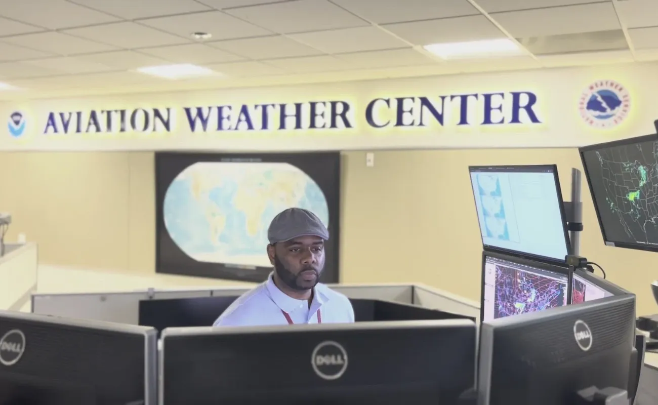 Meteorologist working inside an aviation weather center monitoring pilots flight safety data