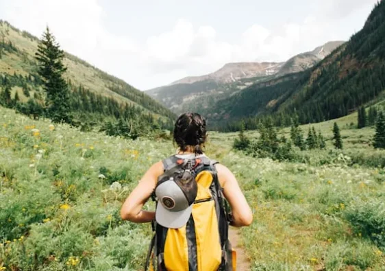 A widow travelling solo with a backpack and a scenic view of mountains