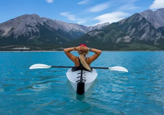 solo alone woman travelling kayak in the middle of the lake