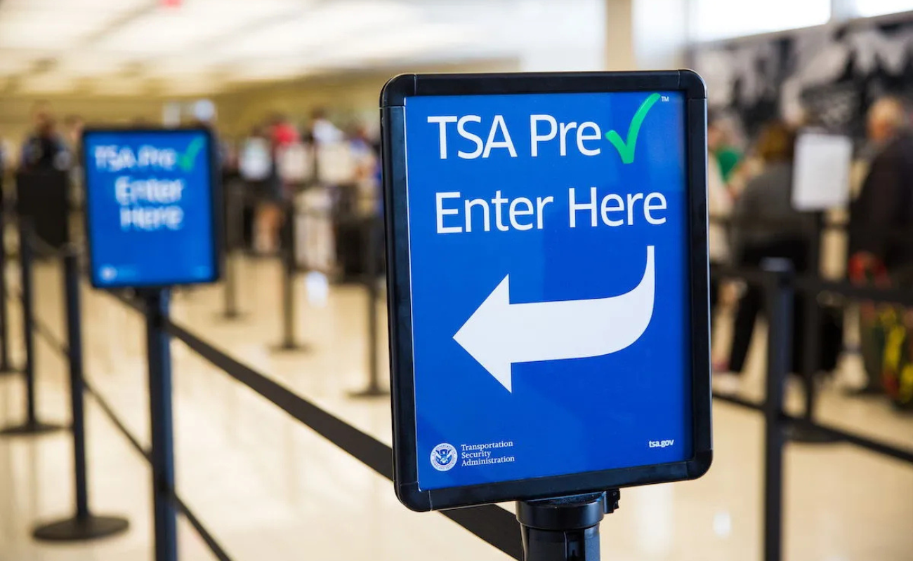 TSA PreCheck entrance sign at an airport security checkpoint, highlighting expedited screening options compared with Global Entry and CLEAR in 2026.