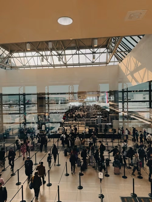 Airplane boarding stairs on the tarmac with aircraft in the background, representing airport security and screening programs such as TSA PreCheck, Global Entry, and CLEAR.